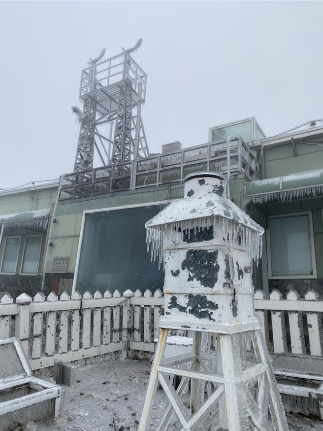 玉山氣象站同仁一早清除風力塔上風速計上的積冰，讓風速計回復運作。圖／中央氣象署提供。