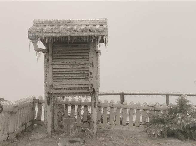 玉山氣象站同仁一早清除風力塔上風速計上的積冰，讓風速計回復運作。圖／中央氣象署提供。