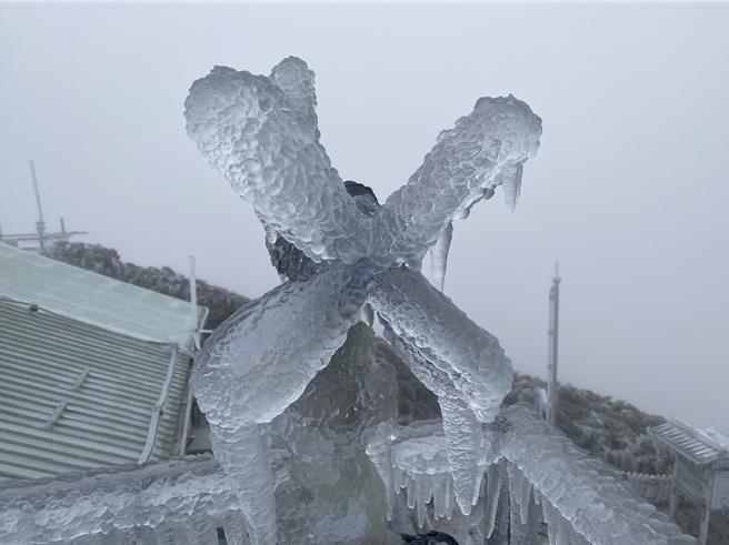 玉山氣象站同仁一早清除風力塔上風速計上的積冰，讓風速計回復運作。圖／中央氣象署提供。