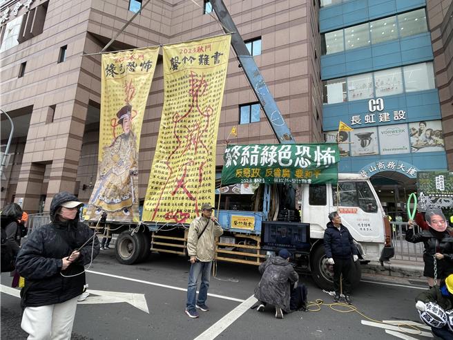 秋斗团体今下午赴赖清德竞总，多名劳工拉起黑色「招魂幡」，请来「民主灵车」奏起哀歌，同时在民进党中央党部挂起「罄竹难书、干谯消灾符」大幅海报。（蔡雯如摄）