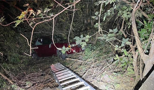 高雄市岡山區菜寮路段24日發生汽車滑落邊坡事故，警消到場救援，架設梯子施救。（翻攝照片／林瑞益高雄傳真）
