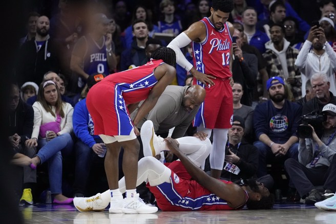 恩比德23日扭伤右脚踝倒地看来相当痛苦。(美联社资料照)