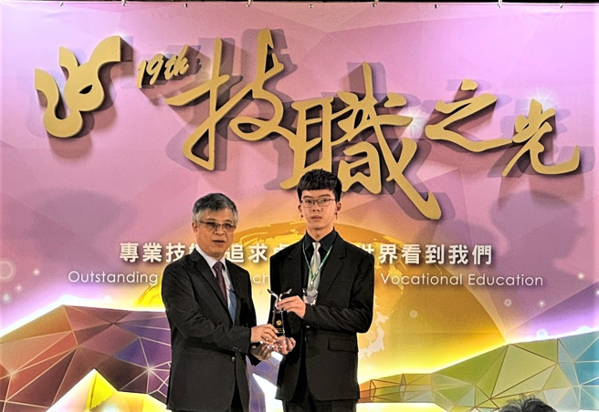 新北高工許凱俊同學(右)從教育部劉孟奇政務次長(左)手中接獲技職之光獎座。(照片/新北教育局提供)