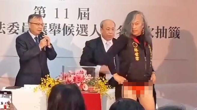 林世伟于立委候选人号次抽籤时，当眾掀起薄长裙露出里面的红内裤。（图／摄自社会事影音）