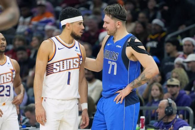 太阳后卫布克(左)与独行侠后卫东契奇交谈。（美联社）