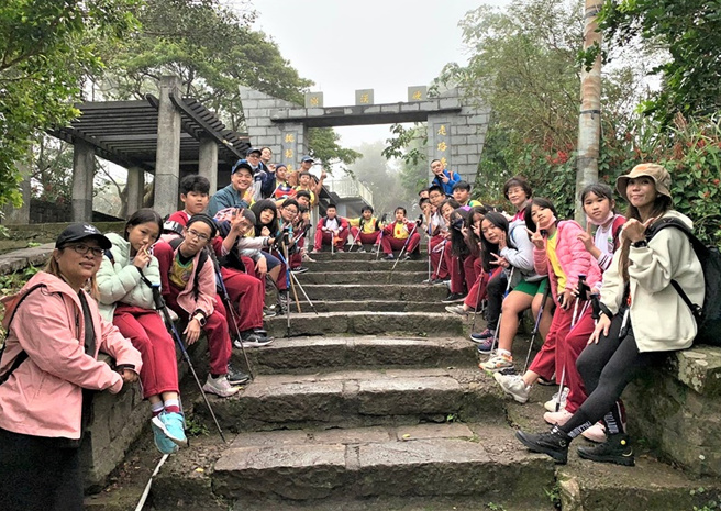 中湖国小的师生与国际见习生Jeff(左6)参与学校校本课程中的山野教育一同攀登硬汉岭。(照片/新北市政府教育局提供)