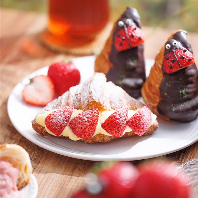 「瓢虫美莓可颂」(右)，瓢虫造型草莓停留在酥松可颂上，吸睛又疗癒；「草莓宝石可颂」(左)如璀璨的红宝石，2款皆售价75元。(八月堂提供)