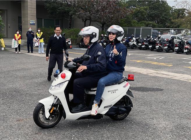 台南市黄伟哲试骑电动警用巡逻机车，并载着市议员林燕祝现场绕行一圈，体验一下电动机车的骑乘感。（洪荣志摄）