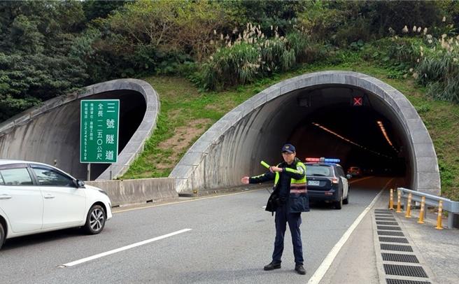 基隆市的台62甲線往四腳亭方向3號隧道，一名林姓大貨車司機未注意到貨車貨物高度超過限高，直接撞上隧道內排風扇風管，卡在隧道內動彈不得。圖為警方疏導交通，避免二次事故。（基隆市警察局提供／徐佑昇基隆傳真）
