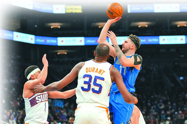 獨行俠控衛東契奇（右）在太陽後衛戴文布克（左）、前鋒杜蘭特面前單手投籃。（路透）