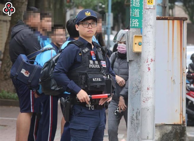 新北某完全中學發生「學生持刀攻擊事件」後，校門口由警方守望學生放學。（本報資料照片）