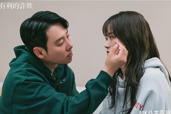 千玗嬉（右）看着金东旭（左）帮她脸上伤口擦药，被导演笑称像在瞪人。（八大提供）