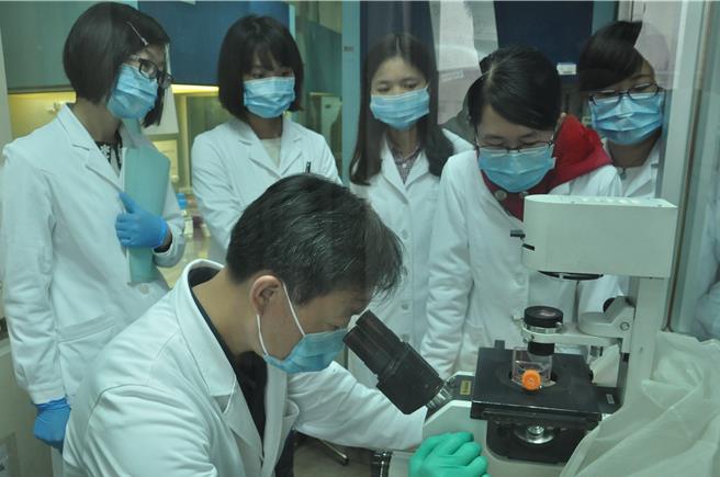 大陆学者首次建立从端粒到端粒的中国人全基因组。图为高占成与研究生在细胞培养间观察细胞生长状态。（北京大学官网）