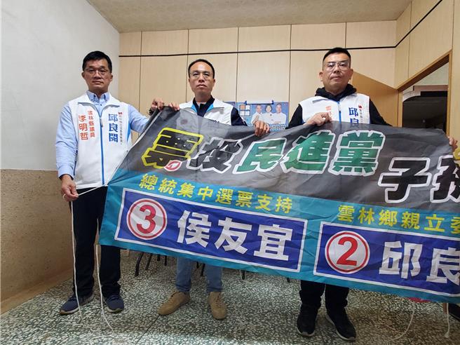 雲林縣二選區立委選舉國民黨籍候選人邱良閱懸掛競選布條「票投民進黨，子孫上戰場」最近在至少4個鄉鎮遭割破或扯壞丟地上，邱良閱（中）29日舉行記者會，縣議員李明哲（左）、縣議員廖偉晴（右）陪同。（周麗蘭攝）