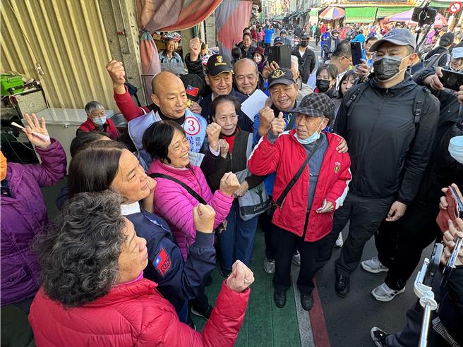 國民黨不分區立委候選人韓國瑜(左四)今早再衝金門金城東門菜市場，合體「女戰神」陳玉珍(左二)沿路拜票，遭韓粉層層包圍要求同框合照。(于家麒攝)