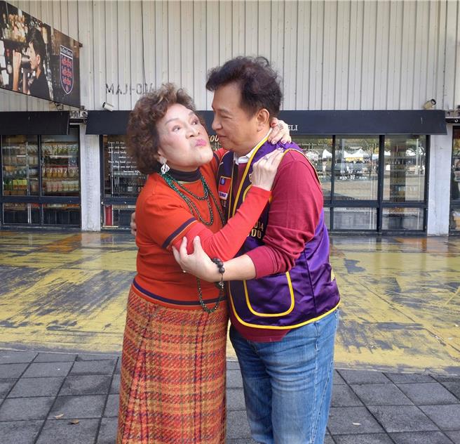 阿姑（左）亲一下老公，夫妻俩一起做公益。（王思颖摄）