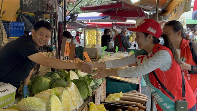 民進黨尋求連任的立委莊競程30日一早與妻子方心慧合體前往位於北屯區的水湳市場分送口罩等文宣小物。（馮惠宜攝）