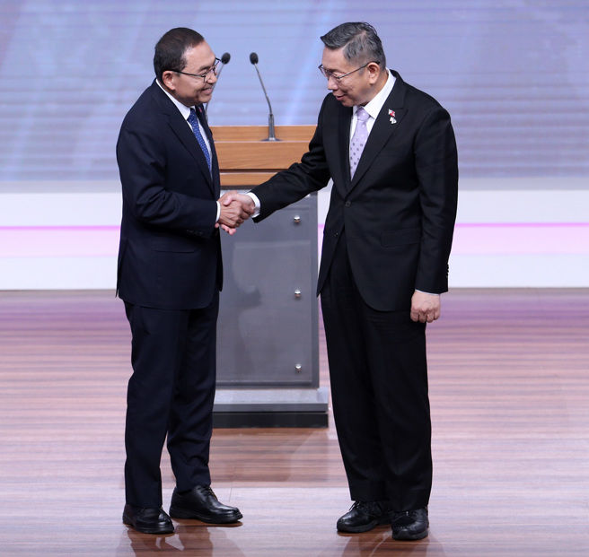 2024年總統大選總統候選人辯論會30日舉行，民進黨總統候選人賴清德、國民黨總統候選人侯友宜、民眾黨總統候選人柯文哲出席，就相關議題相互辯論。圖為侯友宜與柯文哲在辯論會前，彼此互相握手致意。（台北市攝影記者聯誼會提供／黃世麒攝）