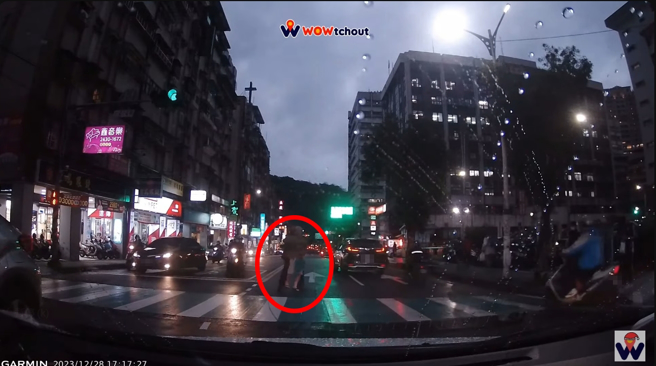 路过骑士看见老人还在马路中，直接下车用擒抱方式，把人扛过斑马线，但这举动却引起网友论战。(图／影片截图)