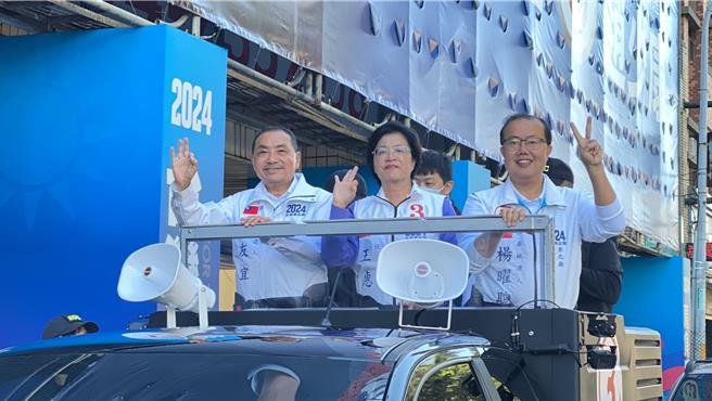 国民党总统候选人侯友宜（左）帮忙彰化县长王惠美（中）繫牢安全扣带后，随即示意车队准备出发。（孙英哲摄）
