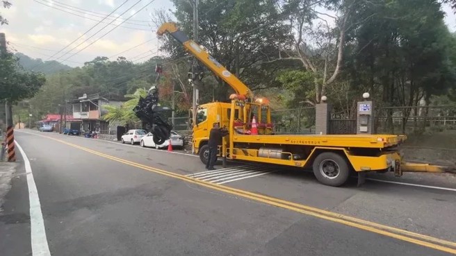 拖吊車將夫妻的黃牌重機拖吊排除現場。（翻攝畫面）