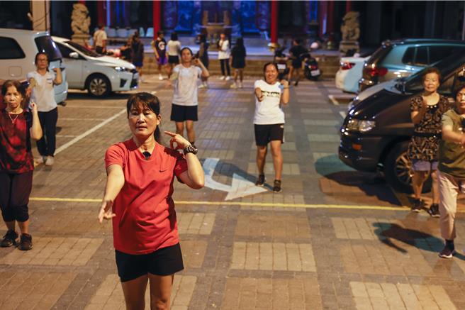 台东都兰部落的小花老师，长期在部落活动中心为部落妈妈及孩子们义务教舞，广场上两群人各聚一方一起练舞跳健康操。（黄子明摄）