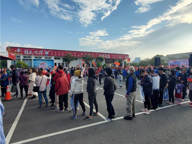 元旦升旗典礼现场，民眾挥舞小国旗排队伍领白萝卜。（周丽兰摄）