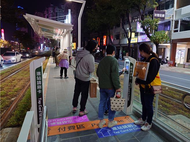 高雄轻轨成圆首日，因改变刷卡计费方式，有派遣工作人员在月台提醒「上下车都要刷卡」。（任义宇摄）