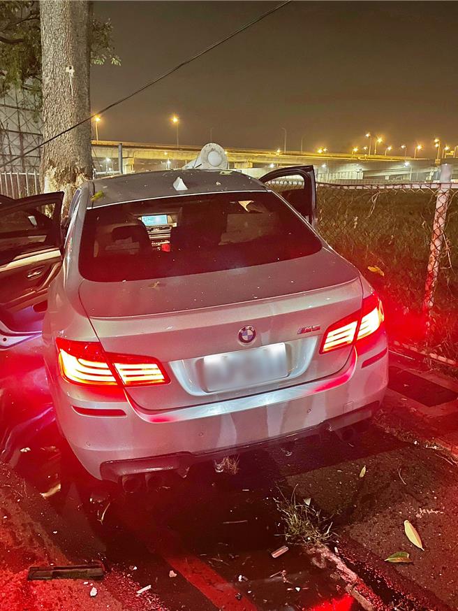 新車要價超過700萬的BNW性能轎車M5，在路口遭撞後，先撞倒路燈後，再撞上路樹，導致車頭全毀，安全氣囊爆開。（警方提供／任義宇高雄傳真）