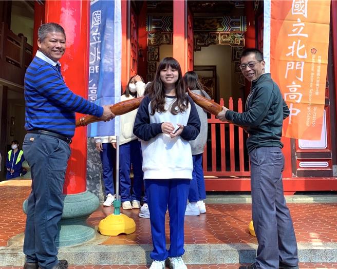 北門高中校長吳俊憲（右）與家長會長葉錦得（左）組成「好運門」，將木雕文昌筆輕點在考生肩頭。（北門高中提供／張毓翎台南傳真）