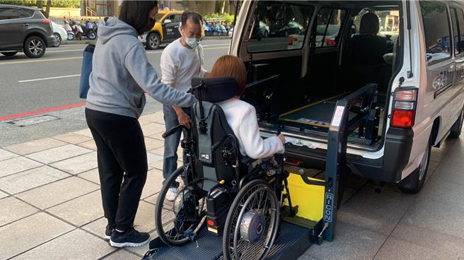 「摩卡咖啡」董事長劉文舉2日捐贈基隆市政府復康巴士1輛，社會處長楊玉欣（右一）也於現場試乘復康巴士的無障礙升降設施。（徐佑昇攝）