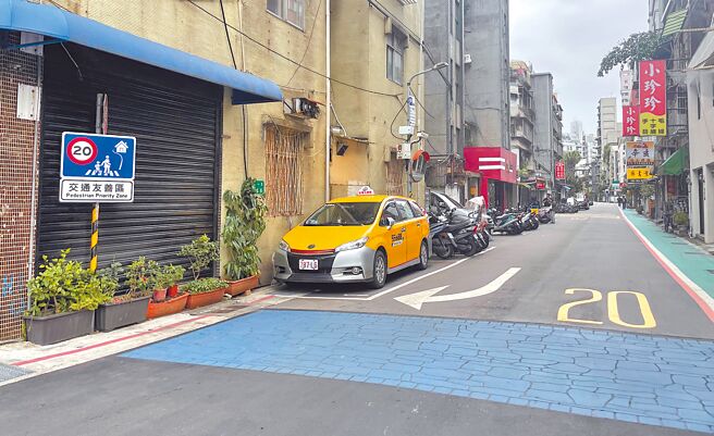台北市大安区大学里建置「交通友善区」，目前已完成部分设施，包括入口意象、弯曲道路和减速丘。入口除有标志牌面外，还有彩色沥青压花，提醒人车已进入交通友善区要减速慢行。（刘彦宜摄）