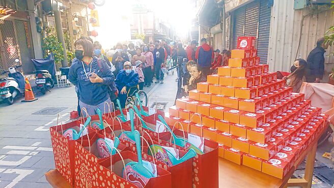 台南市北區舊來發餅舖元旦慶祝創業150年，店家在門口發送400份椪餅，吸引遊客排隊索取，從店門口排到巷口。（程炳璋攝）