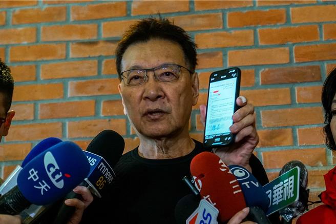 国民党副总统候选人赵少康用手机出示军方公文，指投给民进党就是投战争。（李忠一摄）