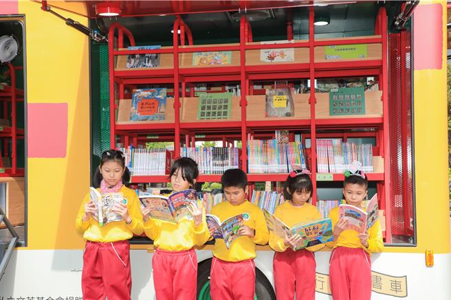 台中市文英基金会捐赠第2部太阳能行动图书车，3日在丰原翁子国民小学举行启用典礼，小朋友们迫不及待，上车寻找自己喜爱的书籍阅读。（台中市政府提供／张妍溱台中传真）