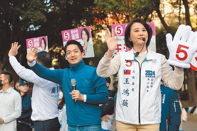 台北市长蒋万安（前左）2日陪同立委候选人王鸿薇（前右）在南京东路与林森北路路口向路过民眾挥手拜票争取支持。（郭吉铨摄）