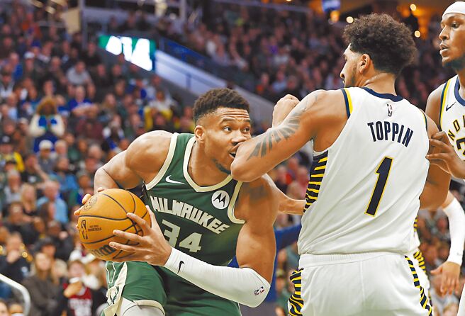 公鹿「字母哥」阿提托康波（左） 持球進攻，嘴巴剛好被溜馬前鋒托平的手肘打中。（美聯社）