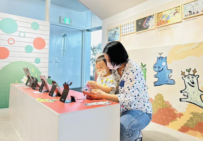 親子讀者於「一筆一畫,讓故事在城市裡發芽」創作班成果展中，一同閱讀繪本小書（圖片來源：高雄市文化局提供）
