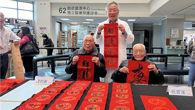 台南市柳营奇美医院4日邀请书法家在一楼大厅写春联及贺词送福，2位名字中都有「龙」字的101岁百岁书法家姚云龙（左）、98岁龙钧贵（右），也到场振笔挥毫。（张毓翎摄）
