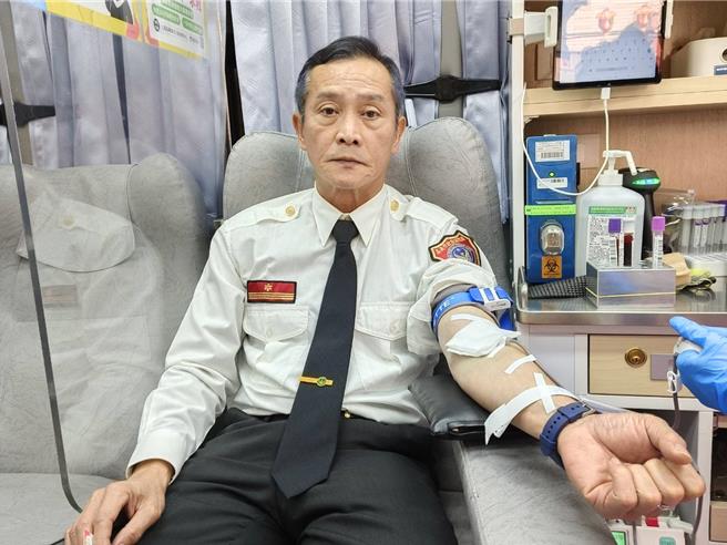 嘉义市消防局副局长郭立昌挽袖捐血，号召大家捐血救人命。（廖素慧摄）