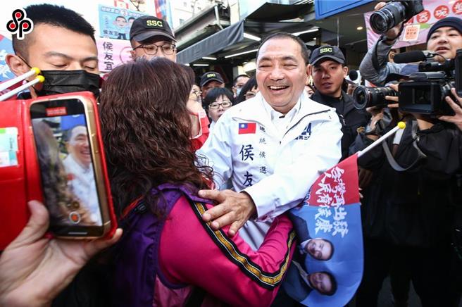 國民黨總統候選人上午前往蘆洲掃街，熱情支持者一度想要偷襲獻吻，不過被維安人員及時制止。（鄧博仁攝）