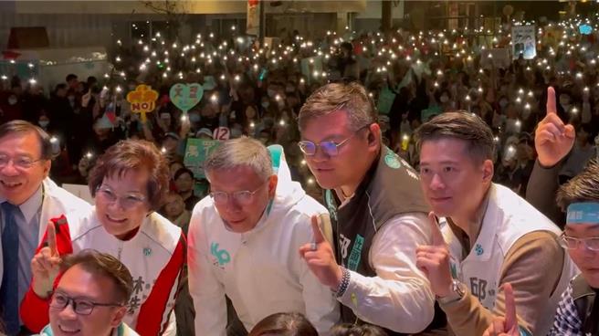 台灣民眾黨總統候選人柯文哲（中）5日晚間在彰化市旭光西路參加「民眾開講」後與黨員幹部合影，支持者打開手機燈光營造溫馨氣氛。（孫英哲攝）