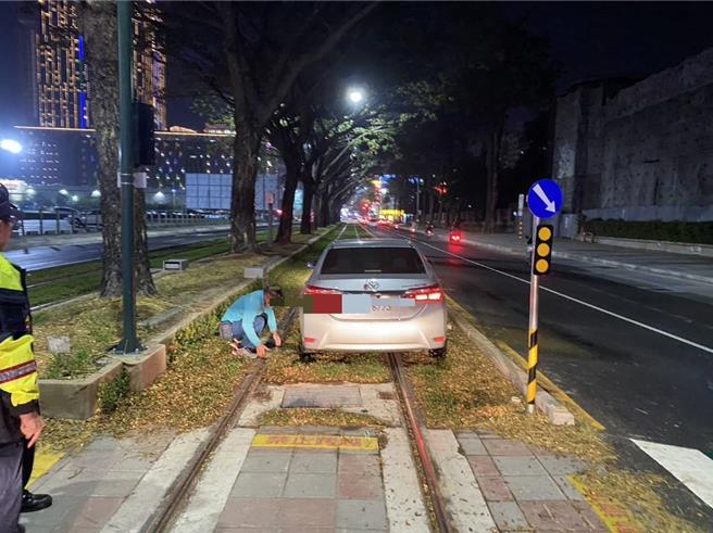 高雄轻轨成圆后出现首起汽车误闯事件，一辆银色轿车疑似路况不熟闯入受困，影响逆行列车44分钟，期间改採公车接驳旅客。（捷运警察队提供／任义宇高雄传真）