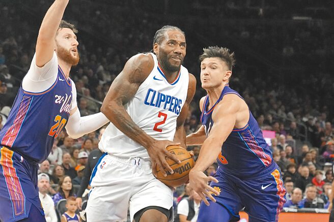 快艇前鋒里歐納德（中）切入突破太陽雙人防守。（美聯社）