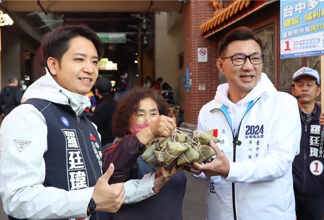 台中市立委六選區國民黨候選人羅廷瑋（左）6日由尋求連任的八選區立委江啟臣（右）陪同到建國市場拜票，呼籲「嚴守司法中立、力抗政治干預」，鄉親要「團結齊步，終結奧步」。（羅廷瑋競總提供／陳淑芬台中傳真）