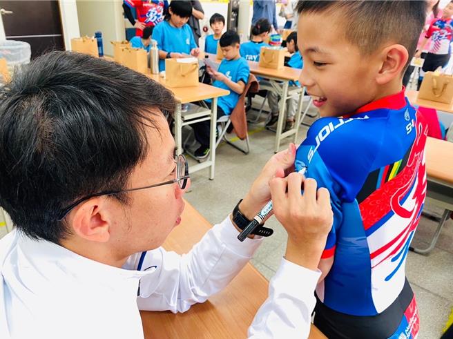 亚运金牌国手黄玉霖到苗栗与蓬莱国小选手相见欢，并为小朋友友签名。（蓬莱国小提供／谢明俊苗栗传真）