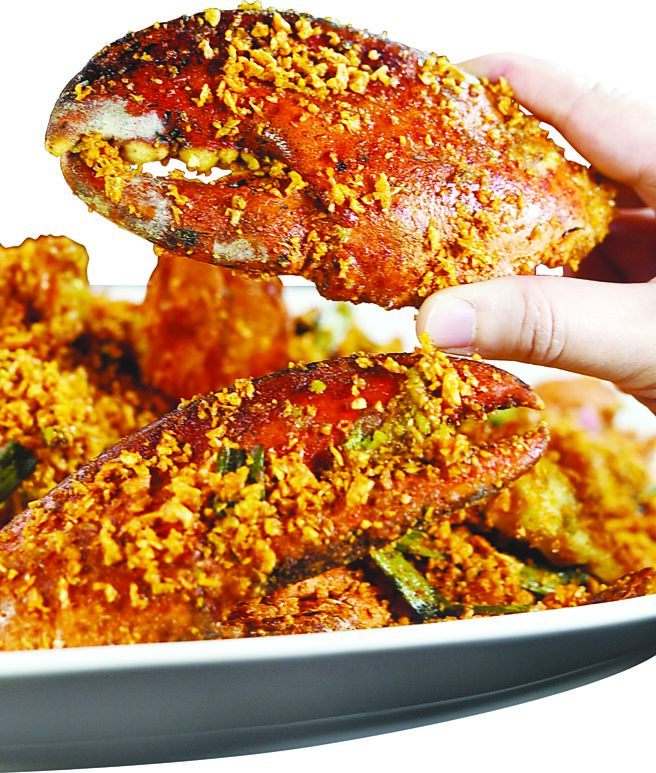 〈避風塘波龍〉是以有兩隻大螯的波士頓龍蝦取代螃蟹炒製，酥香帶有微微辣的蒜酥，是將醃蒜頭與豆豉、雞心辣椒、乾辣椒等多種辣椒炸製而成，再與龍蝦拌炒成菜。圖／姚舜