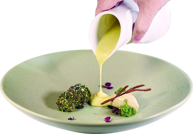 〈龍眼／啤酒／歐當歸〉將歐當歸和伯爵茶蛋白霜打造成小島形狀，啤酒與薑的蛋奶醬意象泥沙淤積河床，使用古法製作的帶殼柴燒龍眼做成冰淇淋。圖／姚舜