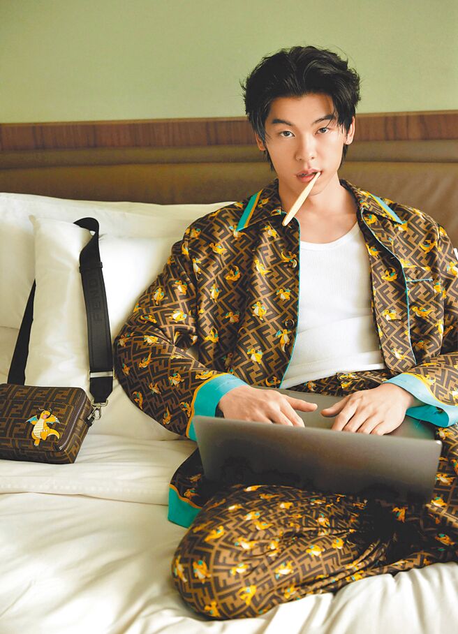 許光漢穿FENDI x FRGMT x POKEMON聯名系列家居服，或坐或躺地在床上用筆電，慵懶帥氣。（FENDI提供）