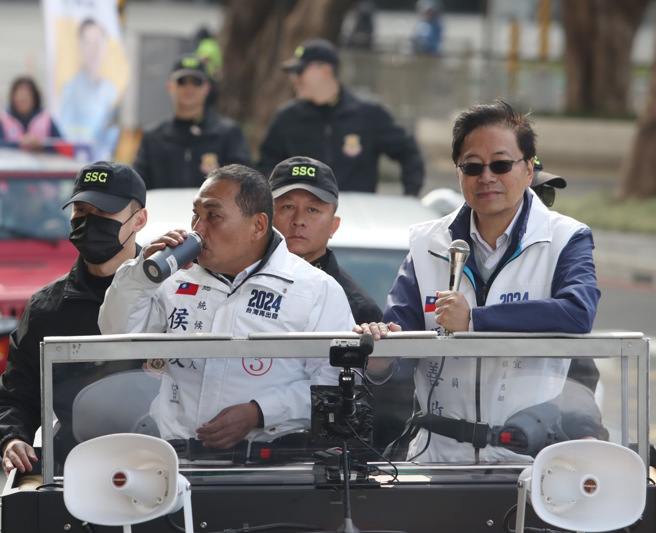 国民党总统候选人侯友宜（左）、桃园市长县长张善政（右）7日在桃园市中坜区，以车队方式扫街拜票，途中候友宜喝水补充水份。（陈怡诚摄）